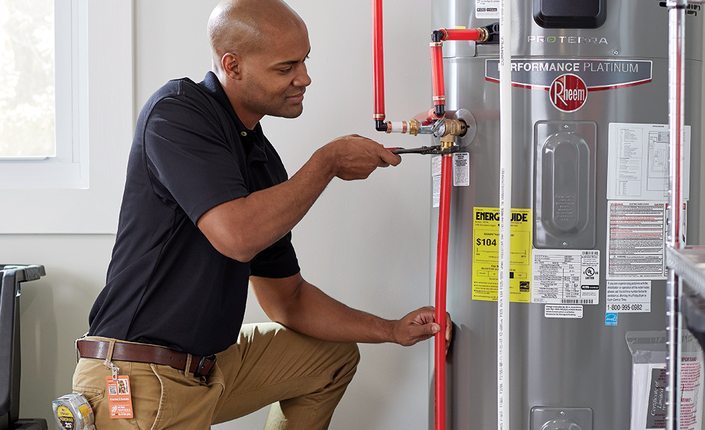 Licensed plumber performing professional maintenance and component inspection on Rheem ProTerra water heater